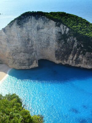 A breathtaking aerial view of Navagio Beach with turquoise waters and lush greenery.